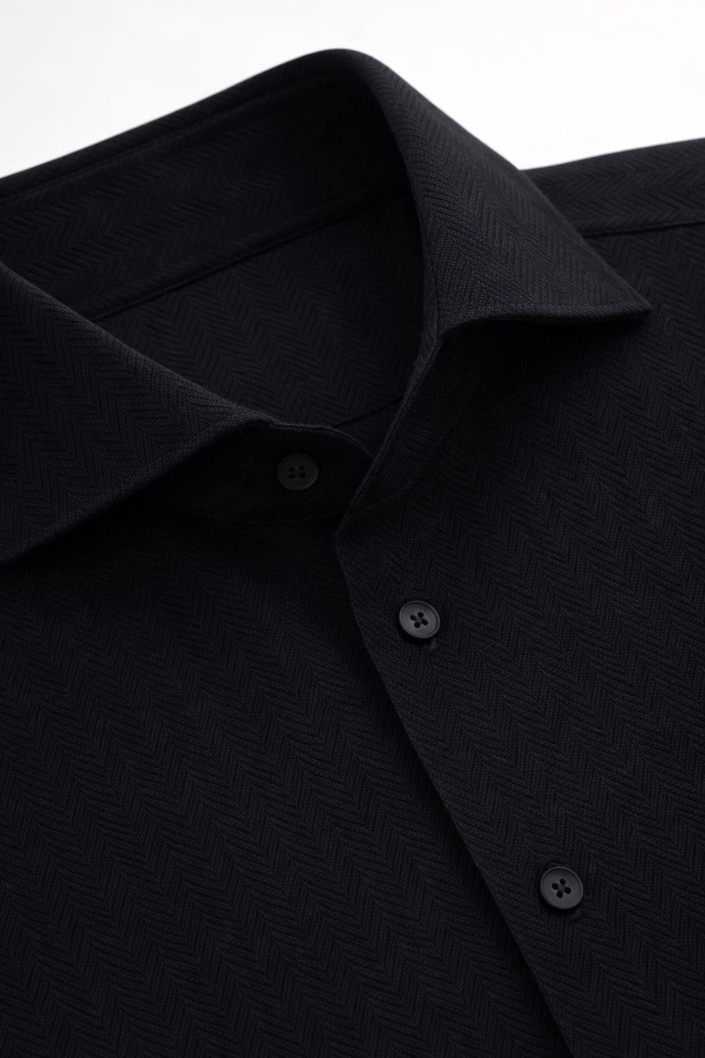 Kragen- und Knopfleisten-Detail beim schwarzen Herringbone-Hemd