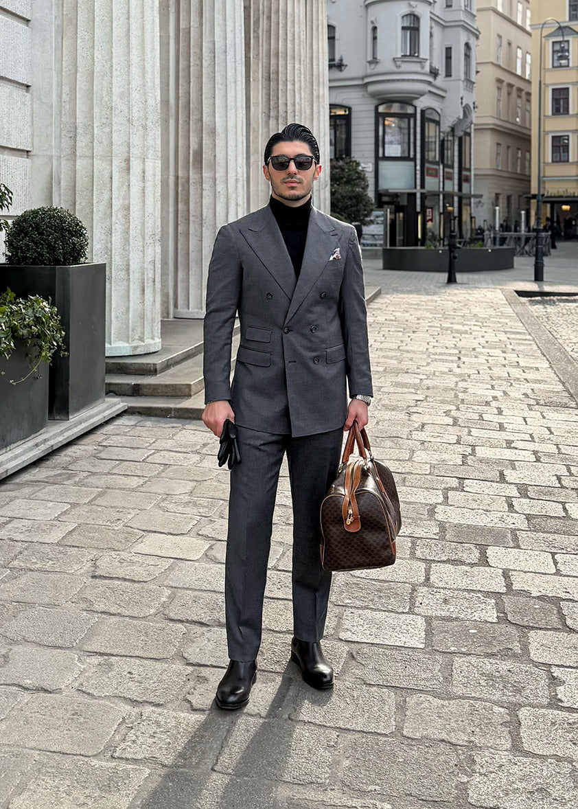 Elegant gekleideter Mann im klassischen Business-Look vor urbaner Architektur.