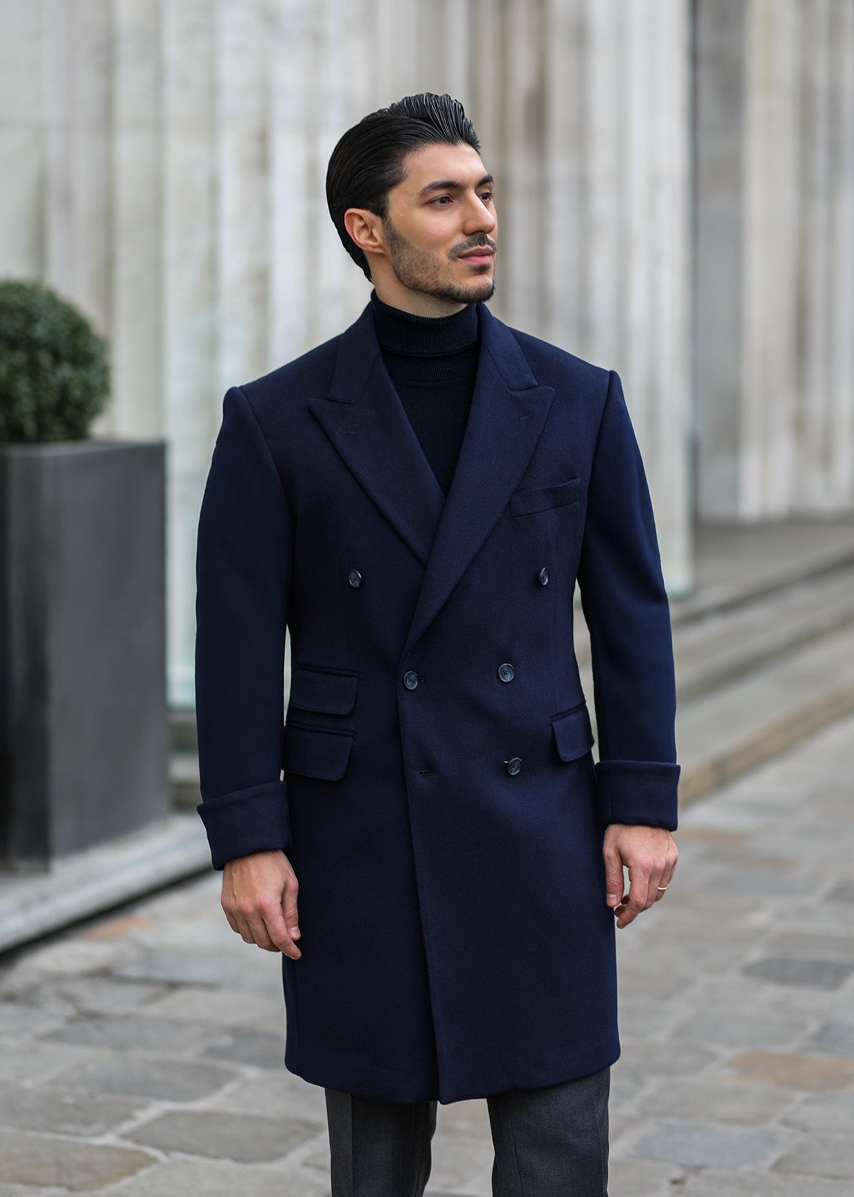 Mann trägt zeitlosen Business-Look mit dunklem Mantel von NobleCut.